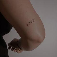 a woman's arm with the numbers 1953 written on it, and her left arm