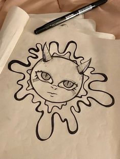 a paper with a drawing of a sun on it and a pen next to it