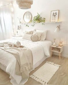 a bedroom with white walls and wooden flooring is decorated in neutral tones, such as linens on the bed