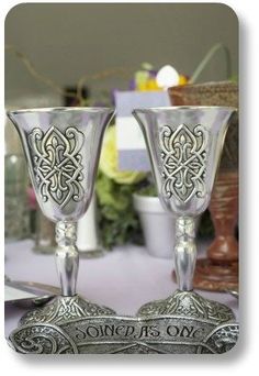 two silver goblets sitting on top of a table