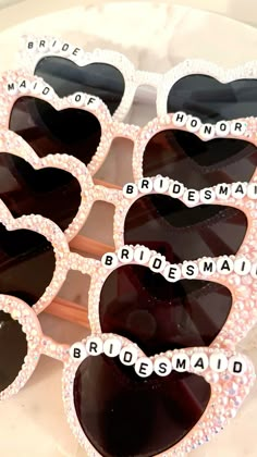 the bridesmaid sunglasses are decorated with hearts and words that spell out their names