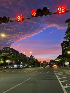 an intersection with traffic lights and buildings in the background at dusk, time lapse