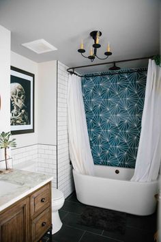 a bath room with a toilet and a bath tub next to a shower curtain on the wall