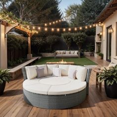 an outdoor living area with patio furniture and string lights strung over the firepits