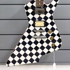 a black and white checkerboard guitar on display