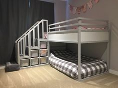 a white bunk bed sitting next to a black and white checkered bedspread