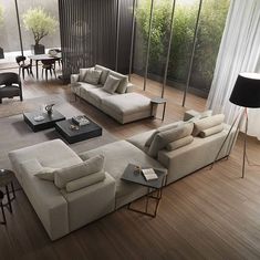 a living room with couches, tables and chairs on the wooden floored floor