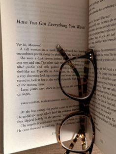 a pair of reading glasses resting on top of an open book