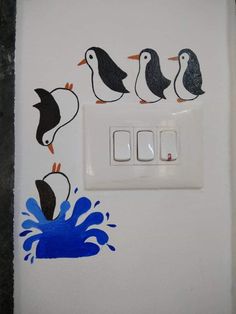 a white light switch with penguins painted on it