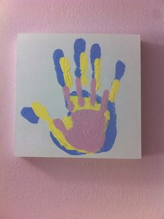 a handprint is on the wall with blue and yellow paint