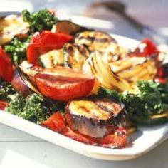 a white plate topped with grilled vegetables on top of a table