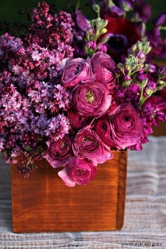 purple flowers in a wooden vase on a table