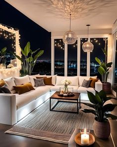 a living room filled with lots of furniture next to tall windows and lights on the ceiling