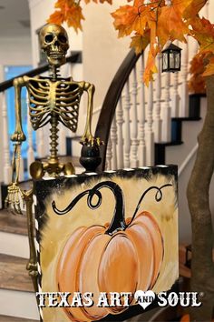 a skeleton sitting on top of a box next to a tree with orange pumpkins