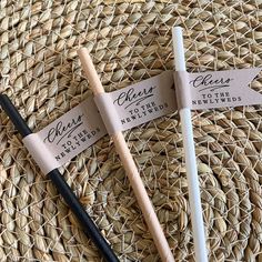 two black and white toothbrushes sitting on top of a woven straw hat covered table