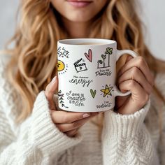 a woman is holding a coffee mug with the words happy on it and images of flowers