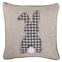 a black and white checkered pillow with a rabbit applique on the front