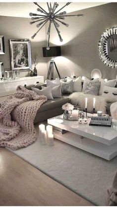 a living room filled with white furniture and lots of pillows on top of the couch