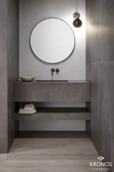 a bathroom sink with a round mirror above it