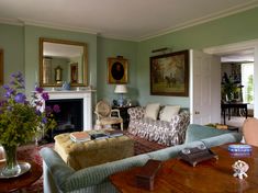 a living room filled with furniture and a fire place under a painting on the wall