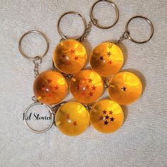 six yellow glass balls with stars are on a keychain that has a name tag attached to it