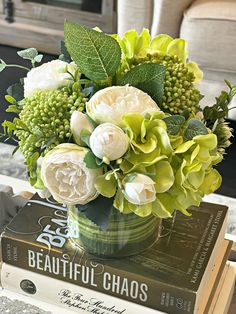 a vase filled with flowers sitting on top of a stack of books