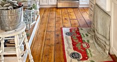 a kitchen with wooden floors and white cabinets, christmas decorations on the counter top and an old fashioned stove