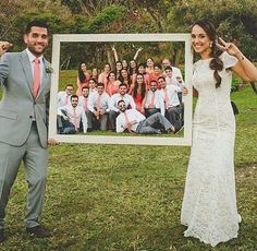 a man and woman posing for a photo in front of a group of people