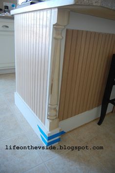 a kitchen island with wooden slats on the top and blue tape across the bottom