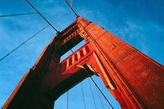 the top of a tall red bridge against a blue sky