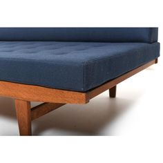 a blue couch sitting on top of a wooden frame