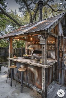 an outdoor bar made out of old shipping containers and pallets with stools around it