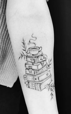 a stack of books with a steaming cup tattoo on the left inner forearm and arm