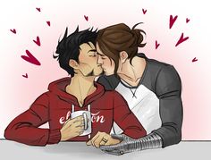 two people sitting at a table, one kissing and the other holding a coffee cup