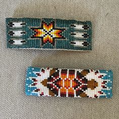 two pieces of beaded fabric with designs on them sitting next to eachother