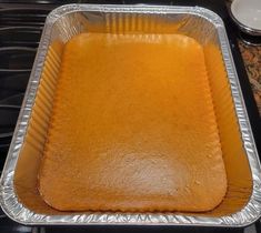 a metal pan filled with food sitting on top of a stove