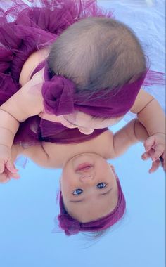 a baby girl wearing a purple tutu in the water