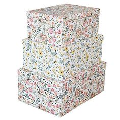 three floral boxes stacked on top of each other, one is white and the other is pink