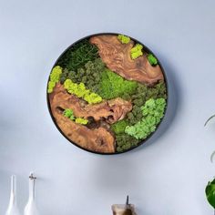 a wall clock with moss and trees on it