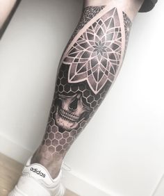 a man's leg with a tattoo on it and a skull in the middle