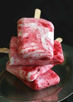 three popsicles on a plate with toothpicks sticking out of the top one