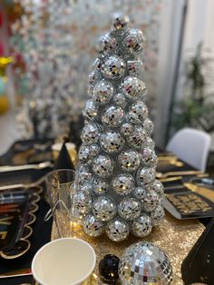 a christmas tree made out of disco balls on top of a table with other decorations