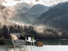 a chair and table in front of a mountain scene wallpapered with foggy mountains