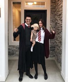 two adults and a child dressed up in harry potter costumes, posing for a photo