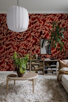 a living room filled with furniture and a large red wallpapered wall next to a coffee table