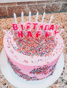 a birthday cake with sprinkles and candles