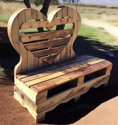 a bench made out of wooden pallets with a heart on it's back