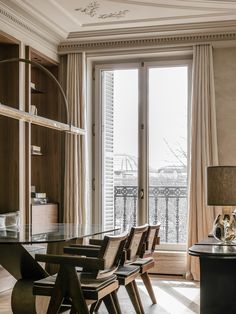 a dining room table and chairs in front of a large window