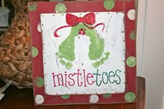 a wooden sign that says mistlet toes on it with green and red polka dots