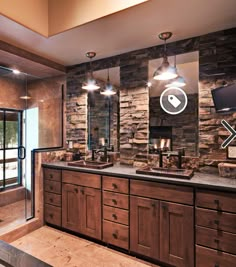 a bathroom with stone walls and wooden cabinets